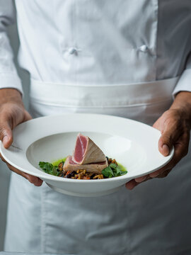 Chef holding spiced Tuna and aubergine dish.fff