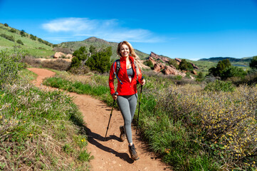 Pretty young woman hiking with iconic Red Rocks in background