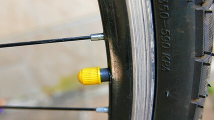 Cycling day. Details of a bicycle front wheel. A close-up shot of a bicycle valve cap. A yellow bicycle valve cover. Spokes of a bicycle wheel. A bike frame. An inner tube cover.