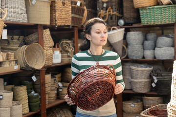 Woman choosing a wicker basket at a hardware store