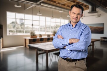 Happy businessman standing at workplace in office