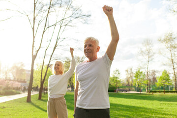 elderly couple of seniors man and woman doing exercises and training in the park outdoors,...