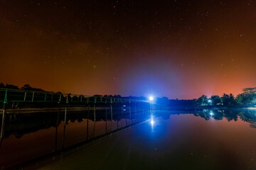 star natural background At night, the Milky Way can be clearly seen with the naked eye, with the blur of light hitting the water surface and the cool, humid air.