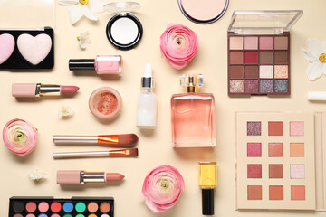 Flat lay composition with different makeup products and beautiful spring flowers on beige background
