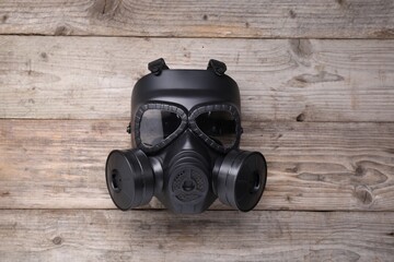 One gas mask on wooden background, top view