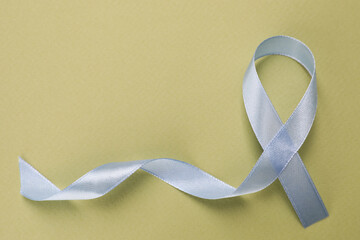 International Psoriasis Day. Ribbon as symbol of support on green background, top view. Space for...