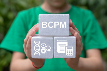 Little girl holding white styrofoam blocks sees abbreviation: BCPM. Biology Chemistry Physics Math...