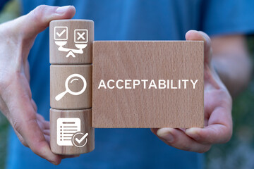 Man holding wooden blocks with icons sees word: ACCEPTABILITY. Acceptability business web concept....