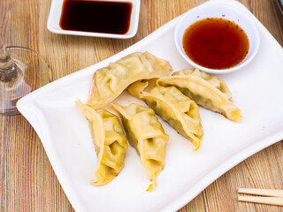 Appetizing steamed dumplings gyoza with soy dipping sauce. Traditional Japanese food..