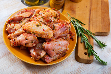 Fresh raw chicken wings pickled with spices on clay plate ready for grilling .. © JackF