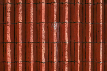 Striped Red Brick wall with sunlight and shadow texture background house facade of building....