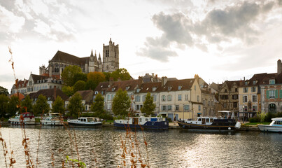 View of city landscape of Auxerre with Cathedral of Saint-Etienne on River Yonne on cloudy autumn...