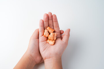 Child holds in hands multivitamins animals pills on white background