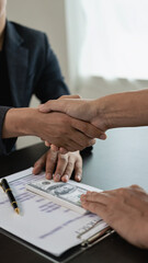 A professional male lawyer in a formal suit shakes hands with a client after making a deal and...