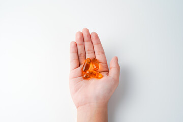 fingers holding a oil filled capsule, soft gel, food supplements, fish oil, omega 3 omega 9