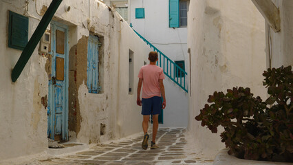 Man walking the beautiful white alleys of Mykonos, Greece
