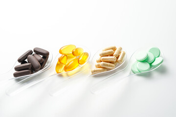Various vitamin and mineral pills in transparent spoon food supplement health product