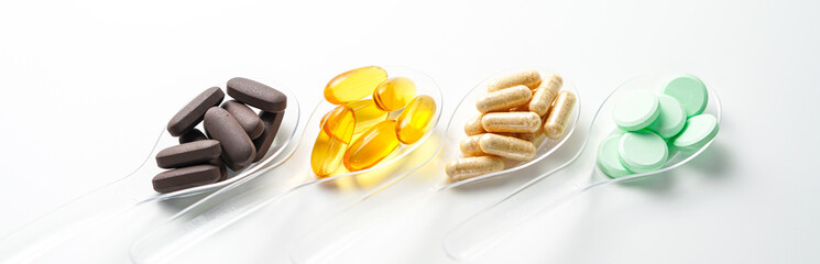 Various vitamin and mineral pills in transparent spoon food supplement health product
