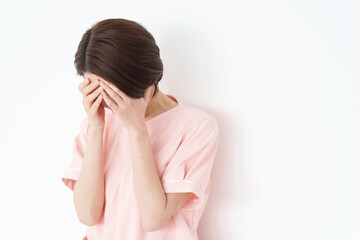 Obraz premium 体調不良の女性看護士（白背景・白バック）