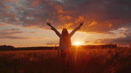 The girl on the top of the mountain raised both hands, the sun was setting. concept of success and achievement, joy, happiness.