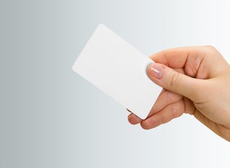 human hand holds a plastic blank bank card
