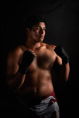 studio portrait latin American male fighter of mixed martial arts on black background 