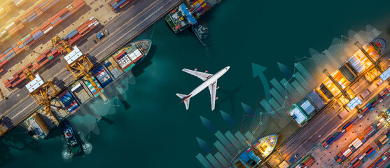 Aerial view and top view cargo plane flying above ship port in the export and import business and...
