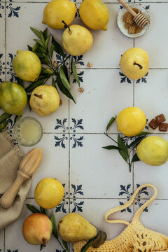 Fresh lemons and pears with leaves. Bag of yellow lemons and  pears with fresh lemon tree leaves on  vintage blue tile background. Flatlay