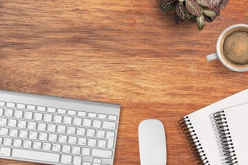 Wooden desk with laptop, notebook and cup of coffee