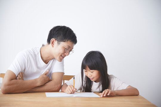 父に宿題を手伝ってもらう女の子
