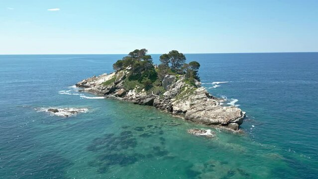 Top view from drone of rocky island with green trees near the town of Petrovac, Montenegro