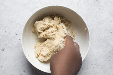 Overhead view of nigerian egg roll dough in a white bowl, overhead view of dough for making egg roll, process of making egg rolls