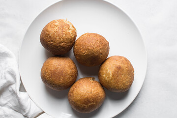 Overhead view of homemade nigerian egg roll, freshly made african egg roll on a white plate, flatlay of egg wrapped in fried dough