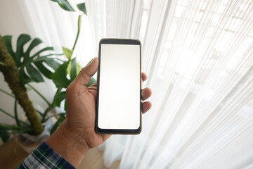 holding smart phone with white screen inside of a home 