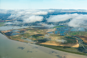 Aerial view of patterns of agricultural fields and the San Francisco Bay where it meets the...