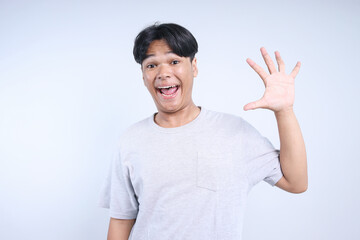 Potrait Of Excited Young Asian Guy Say Hi To You Isolated On White Background
