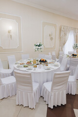 banquet hall decorated for a wedding, white tables and light walls