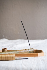 Stick of incense burning on glass tray.