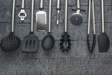 Variety of Kitchen Utensils on Rustic Wooden Background - Spatula, Knife, Tongs, and More
