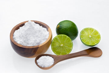 Baking soda in wooden container and lime, isolated on white