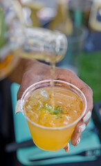 Bartender hand pouring whiskey alcohol in cocktail cup.
