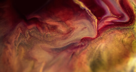 Ink liquid drip. Sparkling paint mix. Defocused red purple golden color shimmering glitter...