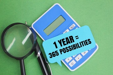 pen, magnifying glass, calculator and paper with the words 1 Year = 365 Possibilities