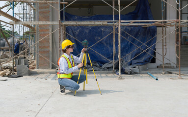 A construction worker is using a laser gauge to capture the setting of masonry, plastering and wall...