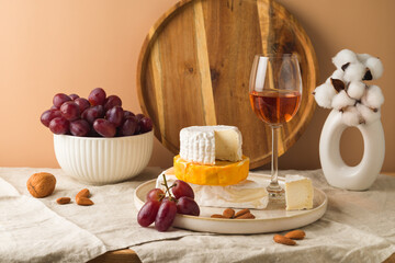 Cheese, grapes, nuts and wine glass on table