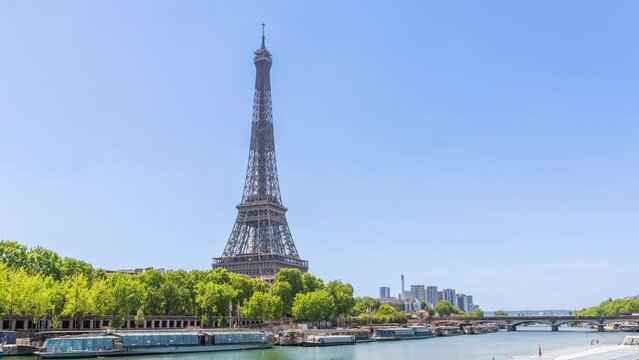 A timelapse of the Eiffel Tower along the river Seine with flyboats passing by with motion blur.Sunny but cloudy spring summer day paris city famous riverside bay tower view bridge timelapse panorama