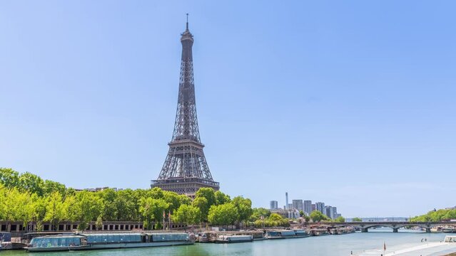A timelapse of the Eiffel Tower along the river Seine with flyboats passing by with motion blur.Sunny but cloudy spring summer day paris city famous riverside bay tower view bridge timelapse panorama