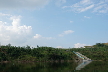 Fototapeta premium a portrait of a reservoir in a village with calm water and green scenery 