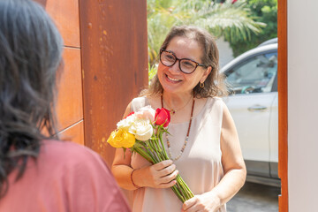 Happy woman with her flowers given to her by her friend