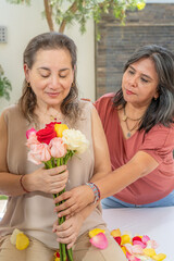 Woman giving a bouquet of roses to another woman